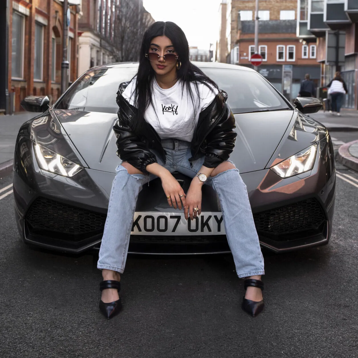 Kooky Club streetwear campaign portrait with a model seated on a sports car