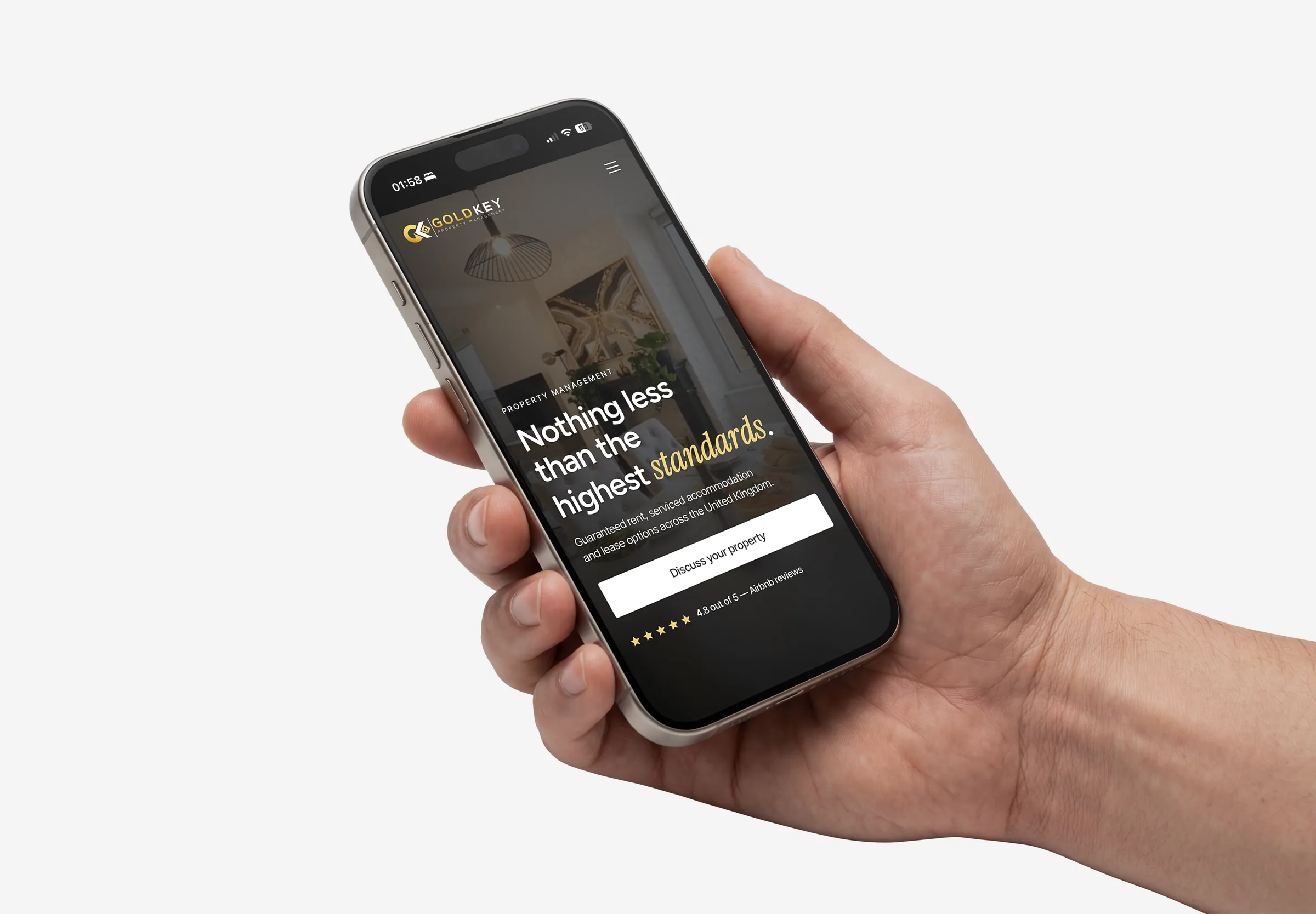 Hand holding a phone showing the redesigned GoldKey homepage